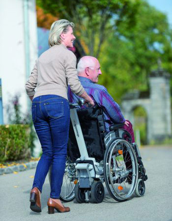 Bild Frau die einen Mann im Rollstuhl schiebt